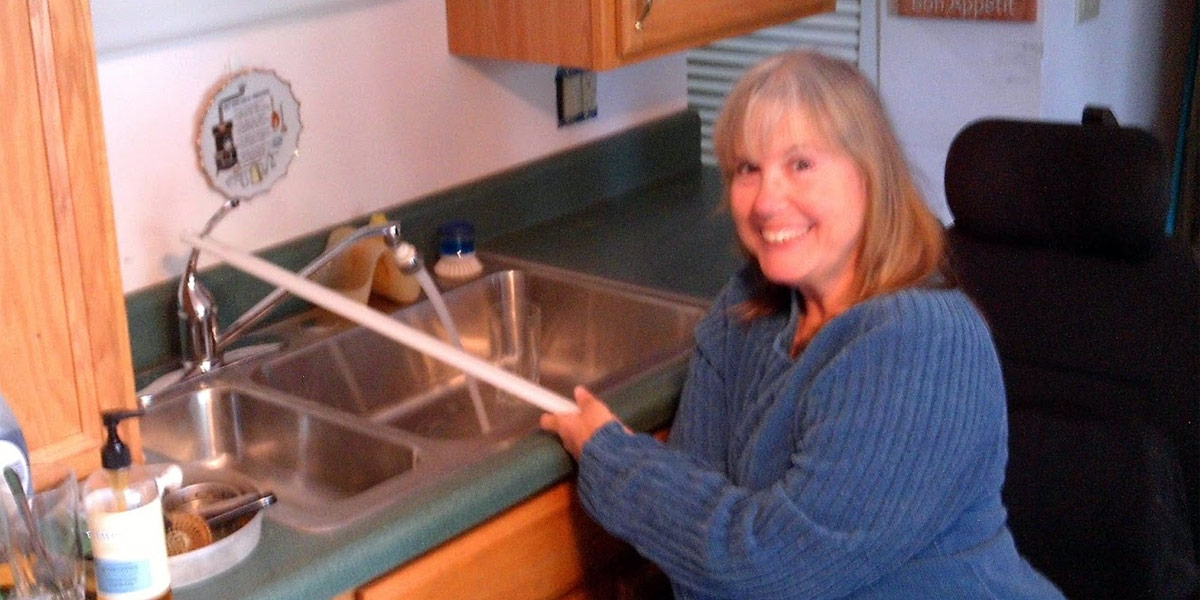 Joyce using her kitchen faucet modification